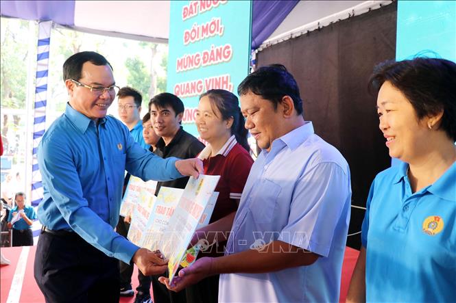 Ông Nguyễn Đình Khang, Chủ tịch Tổng Liên đoàn Lao động Việt Nam trao tặng vé máy bay cho công nhân lao động về quê đón Tết. Ảnh: Thanh Vũ-TTXVN