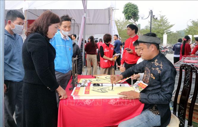 Viết thư pháp tặng người dân. Ảnh: Nguyễn Chinh - TTXVN 