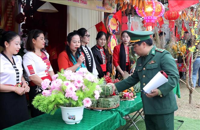 Ban tổ chức chấm điểm phần thi gói bánh chưng tại chương trình. Ảnh: Văn Tý-TTXVN