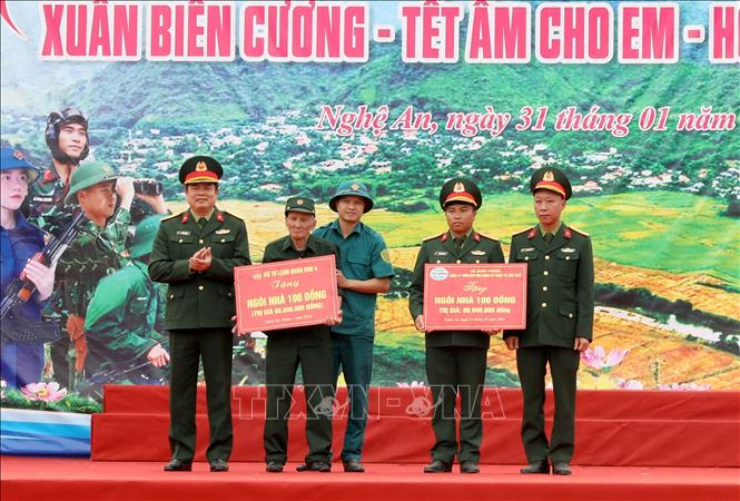 Ban tổ chức trao biểu trưng “Ngôi nhà 100 đồng” trị giá 80 triệu đồng mỗi căn cho các gia đình khó khăn. Ảnh: Văn Tý-TTXVN