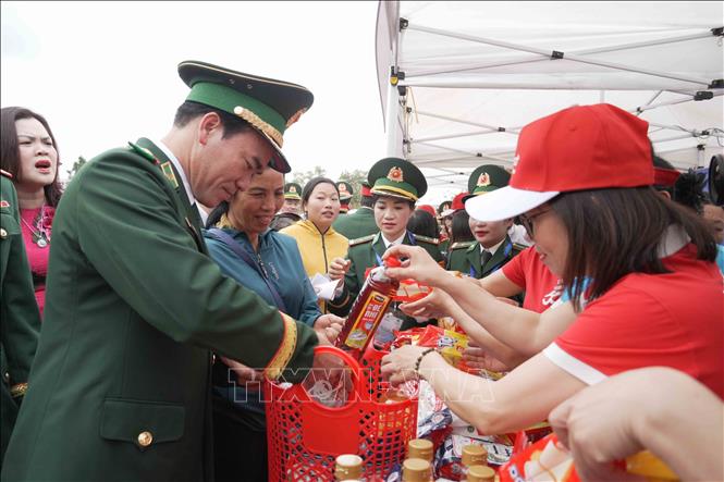 Đại biểu Bộ Tư lệnh Bộ đội Biên phòng động viên người dân tại gian hàng 0 đồng. Ảnh: Hữu Quyết - TTXVN
