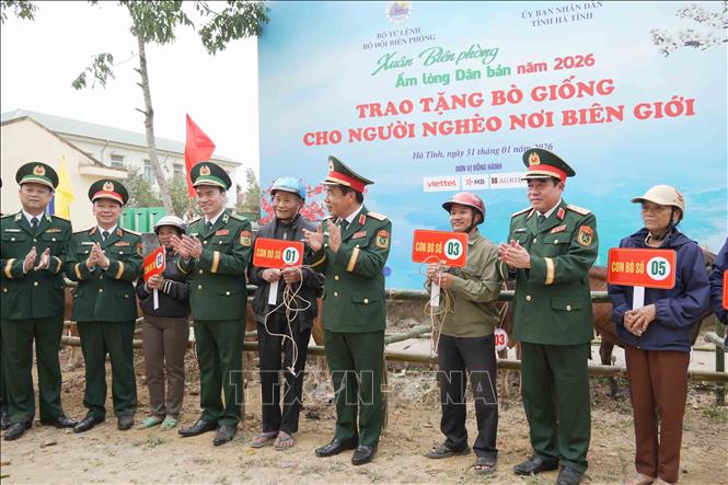 Các đại biểu trao bò giống hỗ trợ người dân vùng biên Hà Tĩnh. Ảnh: Hữu Quyết - TTXVN