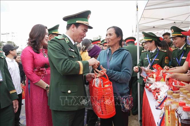 Đại biểu Bộ Tư lệnh Bộ đội Biên phòng trao quà từ gian hàng 0 đồng cho người dân. Ảnh: Hữu Quyết - TTXVN