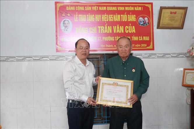 Bí thư Tỉnh ủy Cà Mau Nguyễn Hồ Hải trao Huy hiệu 65 năm tuổi Đảng cho đồng chí Trần Văn Của. Ảnh: Huỳnh Anh - TTXVN