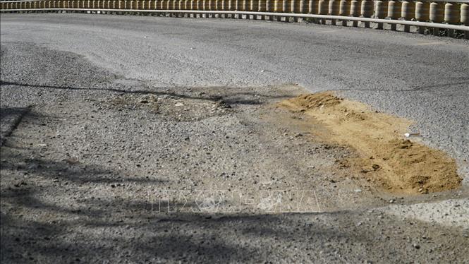 Mặt đường bị bong tróc thành từng mảng lớn. Ảnh: Sỹ Thắng-TTXVN