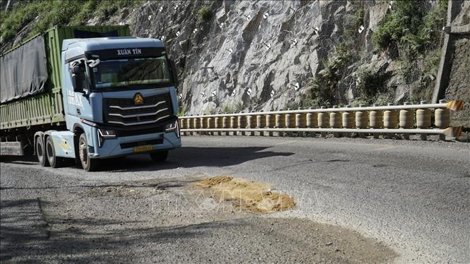 Mặt đường bị hư hỏng khiến nhiều xe tải hạng nặng di chuyển khó khăn. Ảnh: Sỹ Thắng-TTXVN         