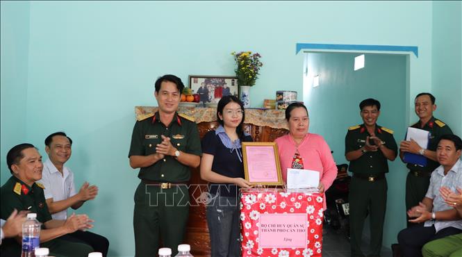 Đại diện gia đình đồng chí Đoàn Ngọc Giàu nhận quà của Bộ Chỉ huy Quân sự thành phố. Ảnh: Hồng Thái - TTXVN