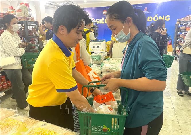 Nhân viên tại siêu thị tư vấn, hỗ trợ người dân mua đồ tại siêu thị 0 đồng. Ảnh: Hương Giang - TTXVN