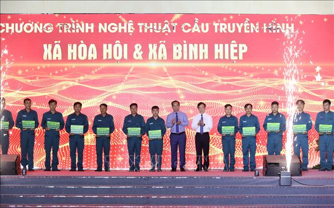 Chủ tịch UBND Thành phố Hồ Chí Minh Nguyễn Văn Được (thứ 8, trái sang) và ông Nguyễn Thanh Tùng, Chủ tịch Hội đồng quản trị Vietcombank (thứ 6, phải sang) tặng quà cho đại diện 20 chốt dân quân. Ảnh: Giang Phương - TTXVN