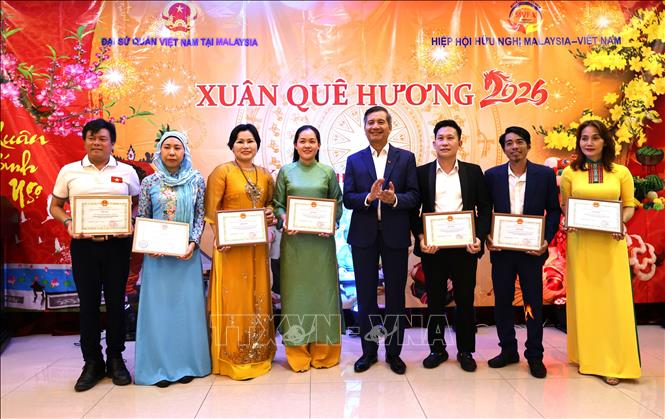 Đại sứ Đinh Ngọc Linh (thứ 5, từ trái) trao giấy khen cho các cá nhân có đóng góp nổi bật cho cộng đồng.
Ảnh: Viên Luyến – Phóng viên TTXVN tại Malaysia.
