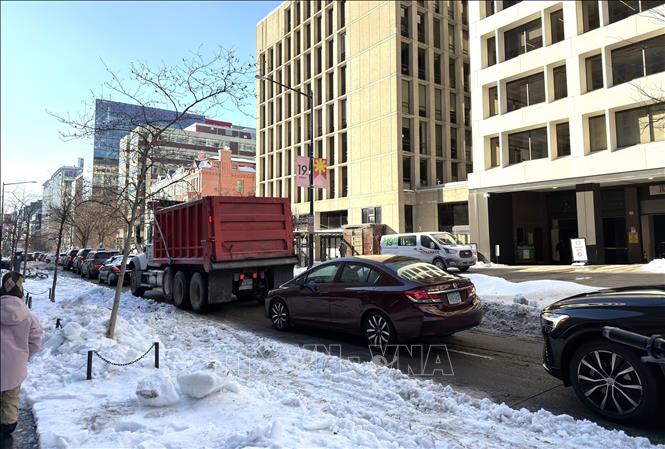 Hàng dài ô tô nối đuôi nhau di chuyển chậm khi mặt đường chỉ còn một làn lưu thông do tuyết và băng chưa được dọn sạch tại thủ đô Washington D.C. Ảnh: Ngọc Quang - PV TTXVN tại Mỹ