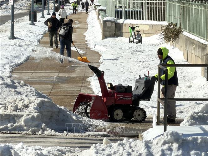 Công nhân sử dụng máy nghiền băng tuyết để phá lớp băng đóng cứng, mở lối đi cho người dân trên một tuyến phố ở Washington D.C. Ảnh: Ngọc Quang - PV TTXVN tại Mỹ