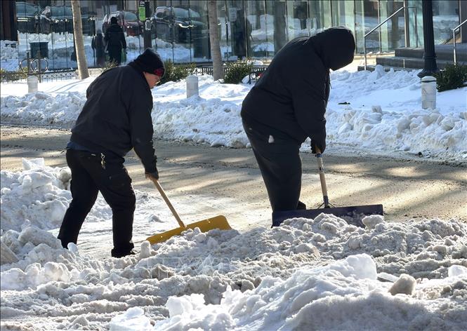 Người dân dọn dẹp băng tuyết sau bão để mở lối đi trên một tuyến phố ở Washington D.C. Ảnh: Ngọc Quang - PV TTXVN tại Mỹ