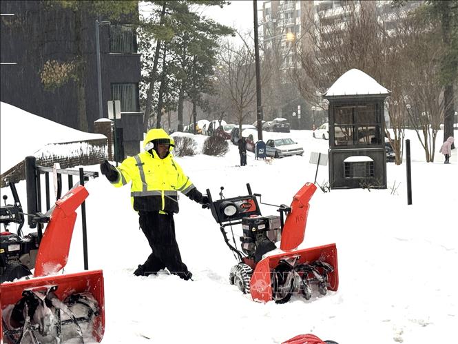 Một công nhân đang khởi động chiếc máy cào tuyết trên đường phố ở thủ đô Washington D.C.	 Ảnh: Đoàn Hùng - P/v TTXVN tại Mỹ