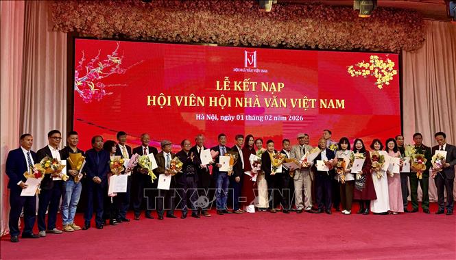 Đại diện Ban chấp hành Hội Nhà văn Việt Nam trao quyết định kết nạp hội viên mới. Ảnh: Phương Lan - TTXVN