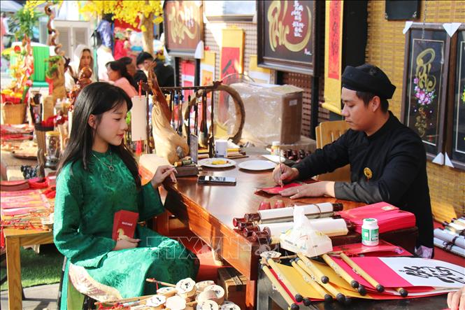 Khách tham quan đến khu vực Phố Ông Đồ xin chữ cho năm mới. Ảnh: Thu Hương - TTXVN