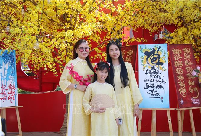 Các gia đình lựa chọn trang phục áo dài để tới tham quan, trải nghiệm tại Lễ hội. Ảnh: Thu Hương - TTXVN