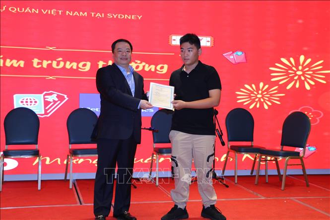 Đại diện hãng hàng không Vietnam Airlines trao tặng giải thưởng cho khách tham dự may mắn trong phần bốc thăm trúng thưởng. Ảnh: Thanh Tú - PV TTXVN tại Australia