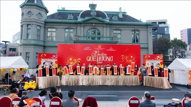 Ban tổ chức, đại biểu trải nghiệm phong tục viết câu đối Tết. Ảnh: Xuân Giao - PV TTXVN tại Nhật Bản