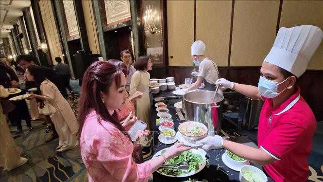 Kiều bào thưởng thức món phở truyền thống của Việt Nam tại Tết cộng đồng. Ảnh: Việt Dũng - P/v TTXVN tại Singapore