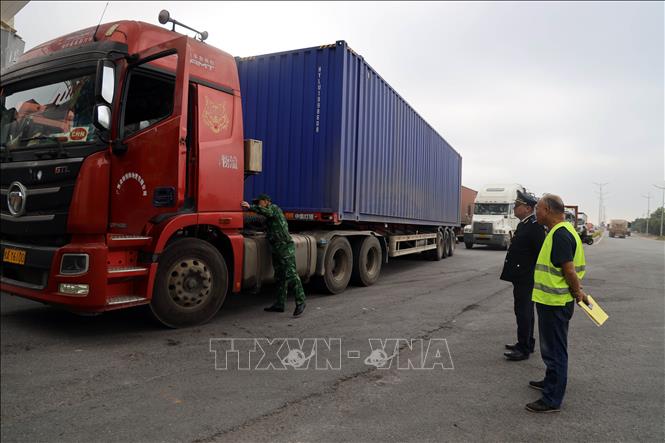 Lực lượng Hải quan Cửa khẩu quốc tế Móng Cái (Chi Cục Hải quan khu vực VIII) phối hợp với Biên phòng Cửa khẩu kiểm tra các xe hàng trước khi thông quan qua cửa khẩu Bắc Luân 2. Ảnh: Đức Hiếu - TTXVN