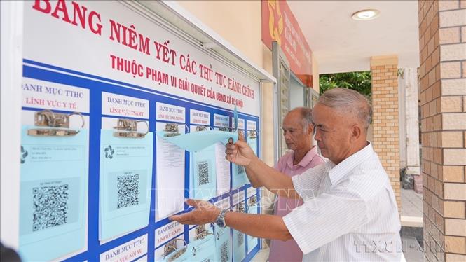 Người dân xã Hòa Hội, tỉnh Tây Ninh tra cứu thủ tục hành chính được niêm yết tại Trung tâm phục vụ hành chính công của xã (1/7/2025). Ảnh: Minh Phú - TTXVN