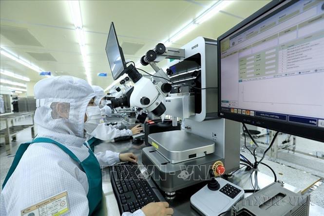 Các công nhân, kỹ thuật viên kiểm tra chất lượng sản phẩm bằng phương tiện máy móc hiện đại tại Công ty TNHH Hana Micron Vina (100% vốn đầu tư của Hàn Quốc), chuyên sản xuất và gia công bảng vi mạch tích hợp sử dụng cho điện thoại di động và các sản phẩm điện tử thông minh khác. Ảnh: Tuấn Anh - TTXVN