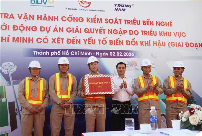 Đại diện lãnh đạo UBND Thành phố Hồ Chí Minh trao quà cho đội ngũ cán bộ, kỹ sư vận hàng cống ngăn triều Bến Nghé. Ảnh: Hồng Đạt - TTXVN