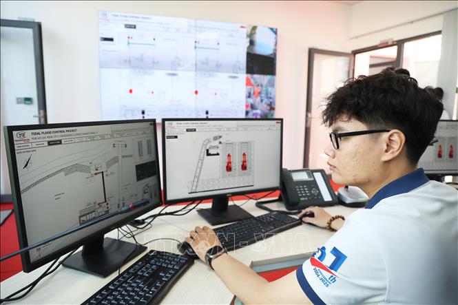 Nhân viên kỹ thuật làm việc trong Trung tâm vận hành cống ngăn triều Bến Nghé. Ảnh: Hồng Đạt - TTXVN