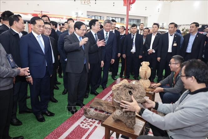 Thủ tướng Phạm Minh Chính và đại biểu tham quan gian hàng tại Hội chợ Mùa Xuân 2026. Ảnh: Trần Việt - TTXVN 