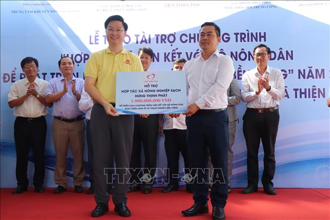Ông Lý Minh Tuấn, Giám đốc Quỹ Thiện Tâm (Tập đoàn Vingroup), trao bảng tượng trưng hỗ trợ vốn ban đầu cho đại diện Hợp tác xã nông nghiệp sạch Hưng Thịnh Phát. Ảnh: Thu Hiền - TTXVN