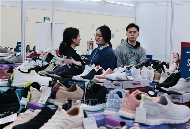 Khách tham quan mua sắm gian trưng bày giày dép tại hội chợ. Ảnh: Trần Việt - TTXVN 