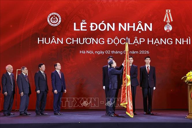 Chủ tịch Quốc hội Trần Thanh Mẫn gắn Huân chương Độc lập hạng Nhì lên lá cờ truyền thống của Ủy ban Pháp luật và Tư pháp của Quốc hội. Ảnh: Doãn Tấn - TTXVN