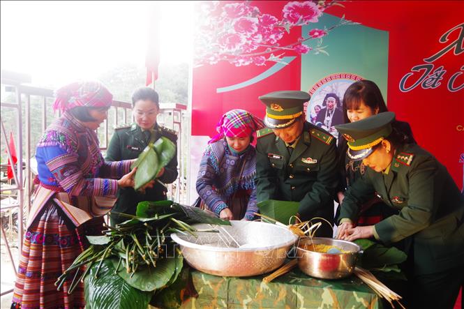 Bộ đội biên phòng tỉnh Lào Cai và nhân dân tham gia gói bánh chưng. Ảnh: TTXVN phát