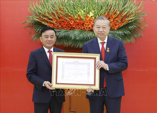 Đồng chí Trần Cẩm Tú, Uỷ viên Bộ Chính trị, Thường trực Ban Bí thư trao Huy hiệu Đảng và chúc mừng Tổng Bí thư Tô Lâm. Ảnh: Thống Nhất – TTXVN