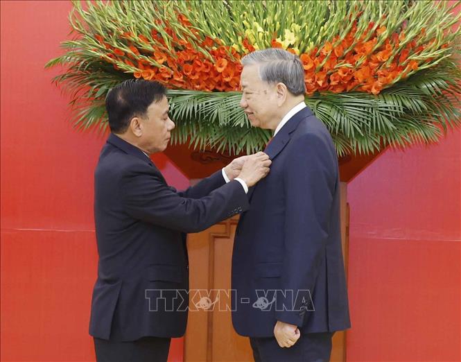 Đồng chí Trần Cẩm Tú, Uỷ viên Bộ Chính trị, Thường trực Ban Bí thư trao Huy hiệu Đảng và tặng hoa chúc mừng Tổng BÍ thư Tô Lâm. Ảnh: Thống Nhất – TTXVN