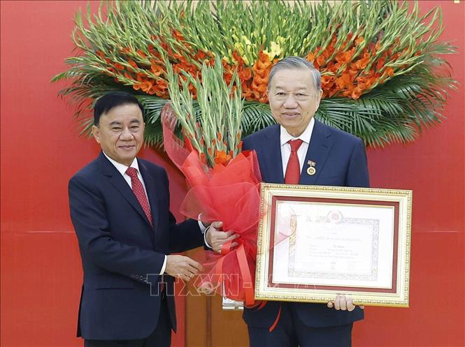 Đồng chí Trần Cẩm Tú, Uỷ viên Bộ Chính trị, Thường trực Ban Bí thư trao Huy hiệu Đảng và tặng hoa chúc mừng Tổng Bí thư Tô Lâm. Ảnh: Thống Nhất – TTXVN