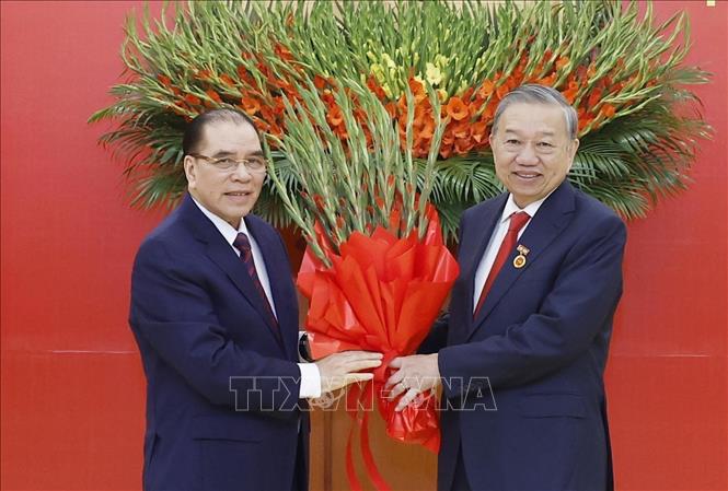 Nguyên Tổng Bí thư Nông Đức Mạnh tặng hoa chúc mừng Tổng Bí thư Tô Lâm. Ảnh: Thống Nhất – TTXVN