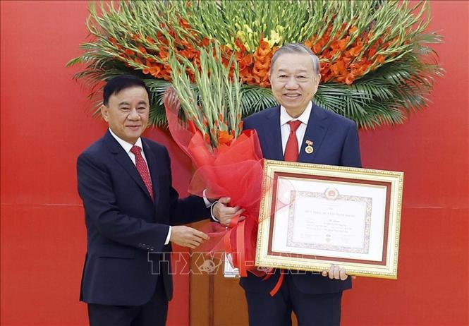 Đồng chí Trần Cẩm Tú, Uỷ viên Bộ Chính trị, Thường trực Ban Bí thư trao Huy hiệu Đảng và tặng hoa chúc mừng Tổng Bí thư Tô Lâm. Ảnh: Thống Nhất – TTXVN