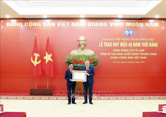 Đồng chí Trần Cẩm Tú, Uỷ viên Bộ Chính trị, Thường trực Ban Bí thư trao Huy hiệu Đảng và tặng hoa chúc mừng Tổng Bí thư Tô Lâm. Ảnh: Thống Nhất – TTXVN