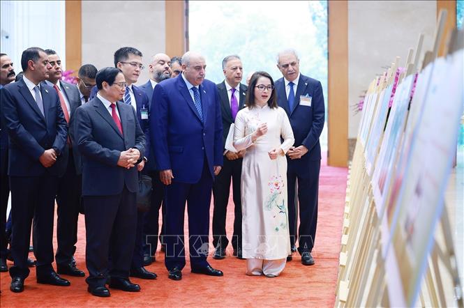 Thủ tướng Phạm Minh Chính và Chủ tịch Hạ viện Jordan Mazen Turki El Qadi tham quan trưng bày ảnh về quan hệ giữa hai nước, do Thông tấn xã Việt Nam thực hiện. Ảnh: Dương Giang-TTXVN