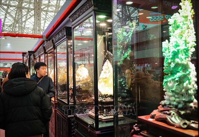 Khách hàng tham quan các tác phẩm điêu khắc bằng ngọc phỉ thuý và thạch anh tóc. Ảnh: Hoàng Hiếu - TTXVN