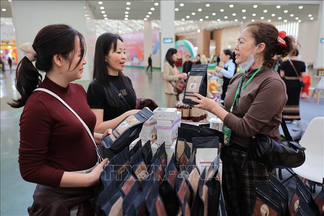 Người dân đến tham quan, mua sắm tại gian hàng sản phẩm OCOP Ê Đê Cafe tỉnh Đắk Lắc. Ảnh: Lê Đông - TTXVN