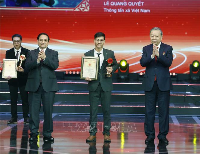 Prime Minister Pham Minh Chinh and Party General Secretary To Lam present 10th Bua Liem Vang’s A prize to journalist Le Quang Quyet of Vietnam News Agency. VNA Photo: Thống Nhất