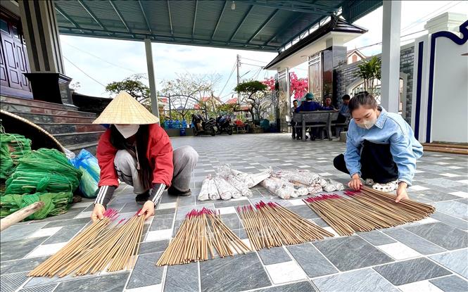 Các hộ sản xuất chăm chút và kiểm tra cẩn thận từng cây hương, hoàn tất các công đoạn cuối cùng trước khi cung ứng ra thị trường phục vụ thị trường dịp Tết cổ truyền. Ảnh: Võ Dung - TTXVN