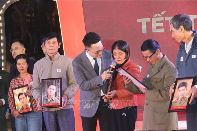Thân nhân gia đình liệt sĩ xúc động đón nhận di ảnh của các liệt sĩ. Ảnh: Hoàng Ngà - TTXVN