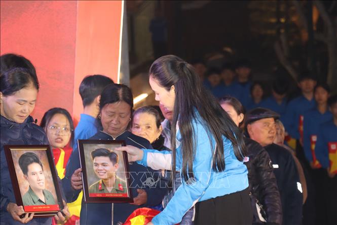 Ban tổ chức trao tặng di ảnh và các phần quà đến thân nhân gia đình các liệt sĩ. Ảnh: Hoàng Ngà - TTXVN
