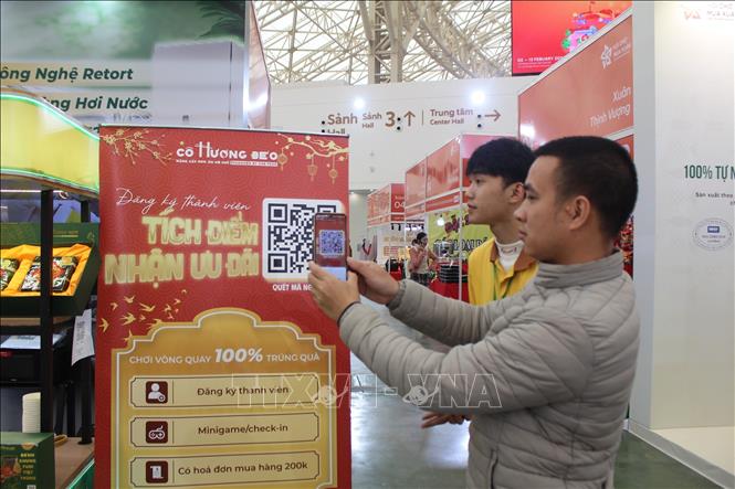 Nhân viên hướng dẫn khách hàng tra cứu thông tin sản phẩm. Ảnh: Nguyễn Thắng-TTXVN