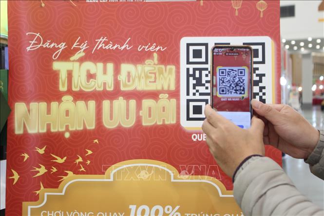 Người dân tra cứu thông tin khuyến mại qua mã QR tại Hội chợ. Ảnh: Nguyễn Thắng-TTXVN