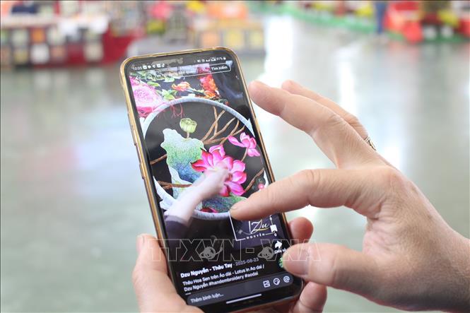 Doanh nghiệp giới thiệu thông tin sản phẩm với khách hàng thông qua các ứng dụng trên điện thoại thông minh. Ảnh: Nguyễn Cúc-TTXVN